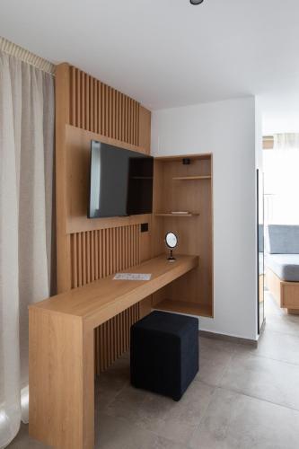 a room with a desk with a flat screen tv at Griffin Suites in Heraklio Town