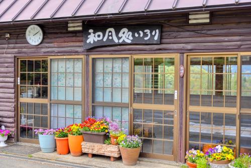 a building with pots of flowers in front of it at 果樹園グランピングヴィラHARASAWA in Minakami