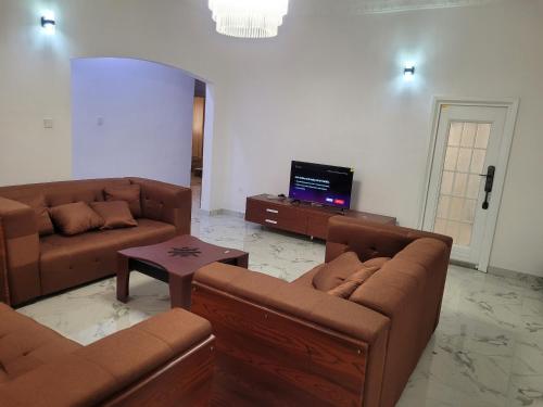a living room with two couches and a tv at Don's Apartment in Lekki