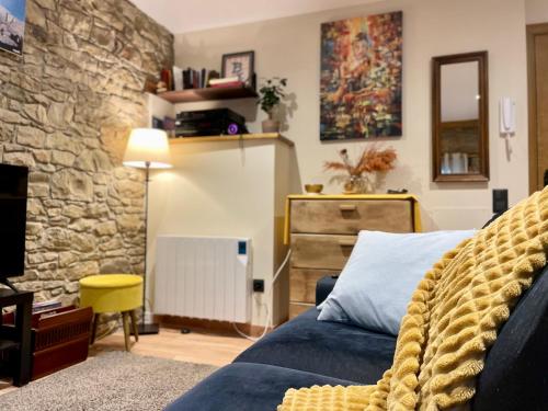 um quarto com uma cama azul e uma parede de pedra em Tavertet un poble preciós em Tavertet
