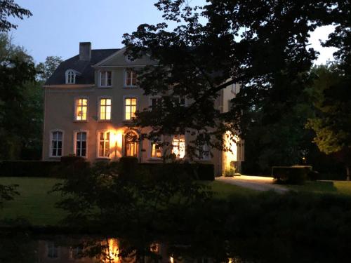 a large white house with its lights on at The Cottage in Merelbeke