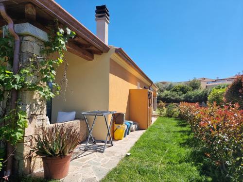a patio with a table in a garden at Residenze di Via Magnolie in Porto Ottiolu