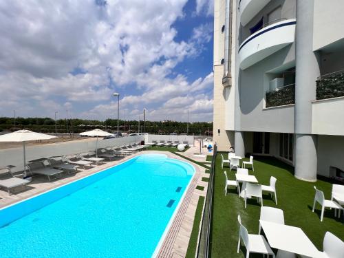 basen na dachu budynku z białymi krzesłami w obiekcie Blue Paradise Hotel w San Mauro a Mare