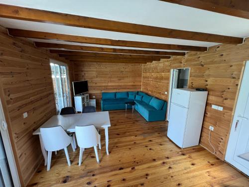 eine Küche und ein Wohnzimmer mit einem Tisch und Stühlen in der Unterkunft Pearl Cottage Ada Bojana in Ulcinj