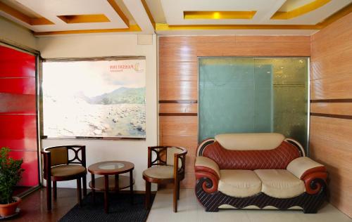 a waiting room with a chair and some stools at Panshi Inn Sylhet in Sylhet