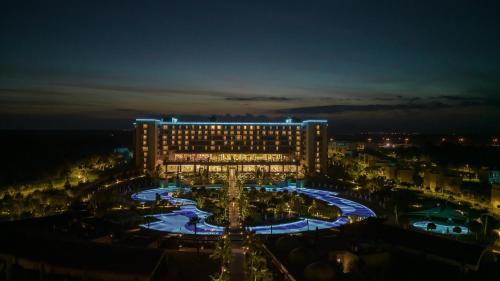 a large building with a pool at night at Concorde Luxury Resort & Casino in Vokolidha