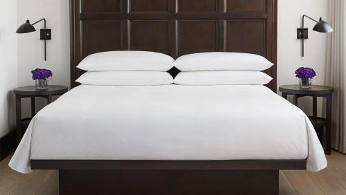 un letto con lenzuola e cuscini bianchi in una camera da letto di Maki zu Hotel a Bahar Dar
