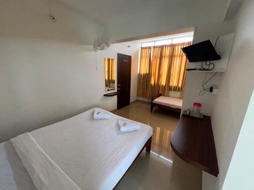 a small room with a bed and a window at HOTEL CHRUCH SIDE in Madikeri