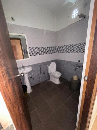ein Bad mit einem WC und einem Waschbecken in der Unterkunft HOTEL CHRUCH SIDE in Madikeri