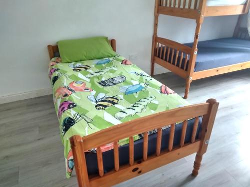 a wooden bed with a green comforter on it at Atlantic Point Stunning Sea View in Bundoran