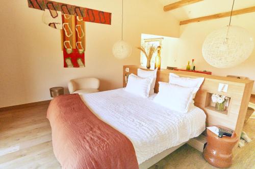 a bedroom with a large bed with white sheets at Domaine de Panery in Pouzilhac