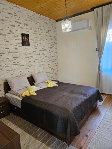 a bedroom with a large bed with a brick wall at Cozy Rooms in Vratsa by Georgievi in Vratsa