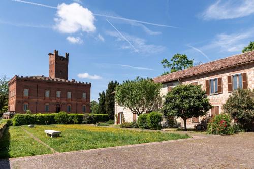 an old brick building with a tower on top of it at Uviglie Apartments in Rosignano Monferrato