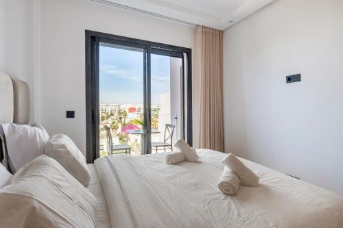 a white bed in a room with a large window at Tribeca 3 - Casablanca Center in Casablanca