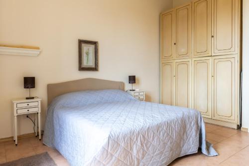 a bedroom with a white bed and two night stands at Uviglie Apartments in Rosignano Monferrato
