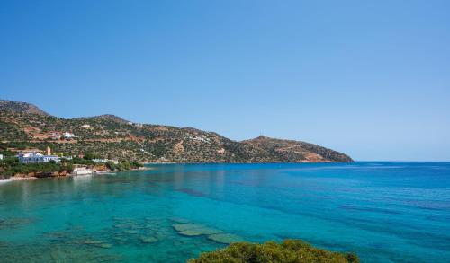 a view of a beach with blue water at Havania Apartments in Agios Nikolaos