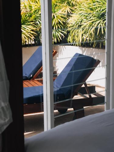 a view of a window with a blue chair outside at The Nine Mirissa in Mirissa