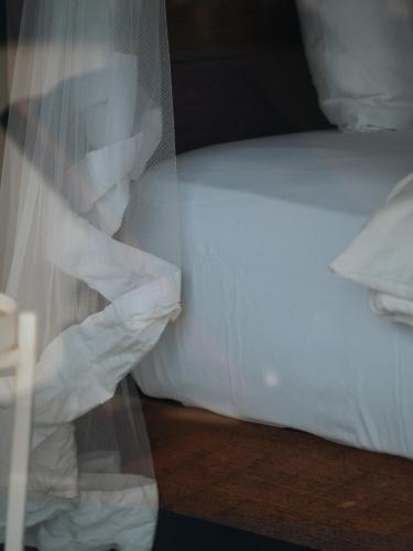 a close up of a bed with white sheets at The Nine Mirissa in Mirissa
