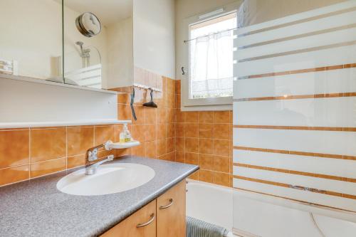 a bathroom with a sink and a tub at Vue exceptionnelle à Saint-Clair pour 4 personnes in Le Lavandou