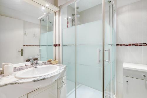 La salle de bains est pourvue d'un lavabo et d'une douche en verre. dans l'établissement T2 vue mer à Saint-Clair, au Lavandou