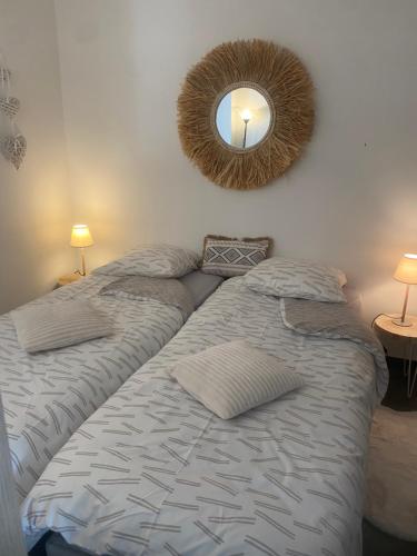 um quarto com 2 camas e um espelho na parede em Jetez l'ancre à la marina de deauville em Deauville