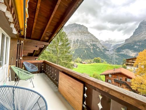 a balcony with chairs and a view of mountains at Bodmi on the top Apartment - Aare Jungfrau AG in Grindelwald