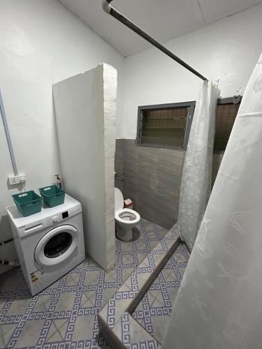 a bathroom with a washing machine and a toilet at Big & beautiful house for 3 - Osu center Potbelly in Accra