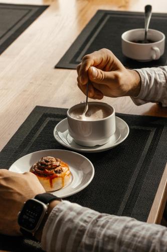 a person is stirring a cup of coffee on a table at Rest&Ski Spa Resort in Bukovel