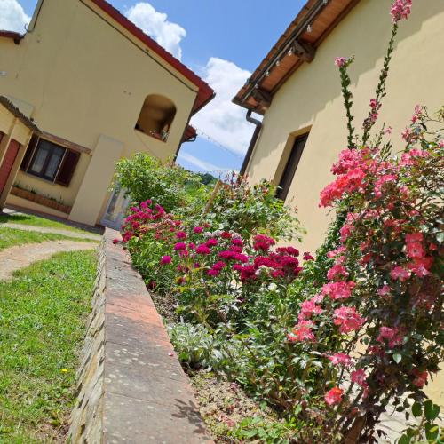 a garden in front of a house with pink flowers at Guest House Torre Guelfa, Vinsantaia in Figline Valdarno