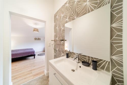 a bathroom with a white sink and a mirror at Villa Ilyana - bord de mer- piscine chauffée in La Saline les Bains