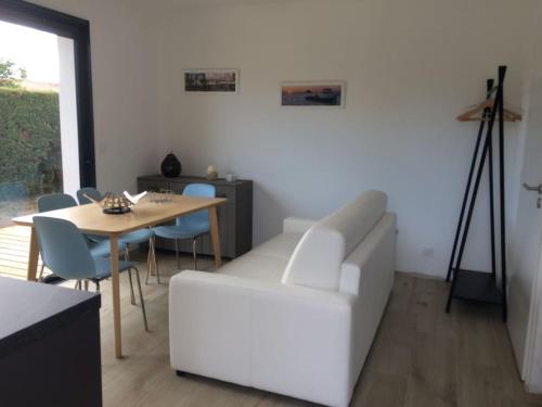un salon avec un canapé blanc et une table dans l'établissement Joli studio de 25m2 avec terrasse, idéal pour un couple, à Gujan-Mestras
