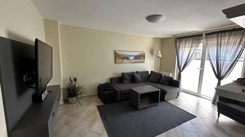 ein Wohnzimmer mit einem Sofa und einem Flachbild-TV in der Unterkunft Sonnenseite in Laboe