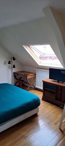 - une chambre avec un lit, un bureau et une lucarne dans l'établissement Le Nid d'Anatole, au Mans