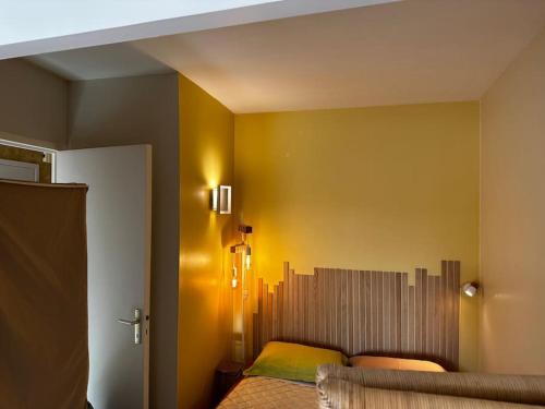 ラ・ボールにある3Très Beau logement, idéalement situé , Plages, Port & Vélo à Dispの黄色の壁のベッドルーム1室