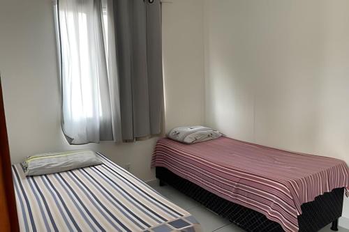 um pequeno quarto com uma cama e uma janela em Casa condomínio fechado. em Petrolina