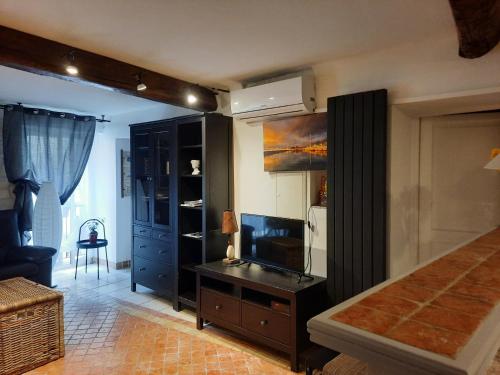 uma sala de estar com televisão e um quarto em Vieille Ville 1 - Luca's Apartment, 1 bedroom, max 2 adults and 2 kids em Antibes