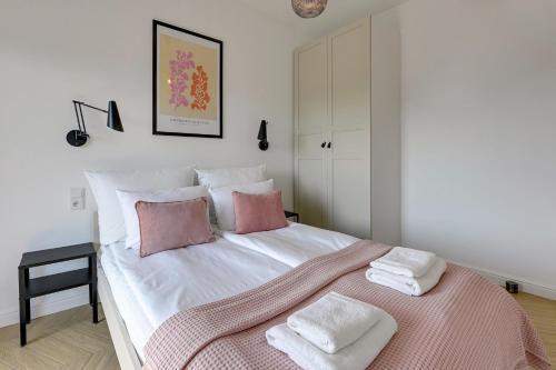 sypialnia z dużym białym łóżkiem z różowymi poduszkami w obiekcie Apartament Gdańsk My Way, Parking, Kids Play & Gym by TriApart w Gdańsku