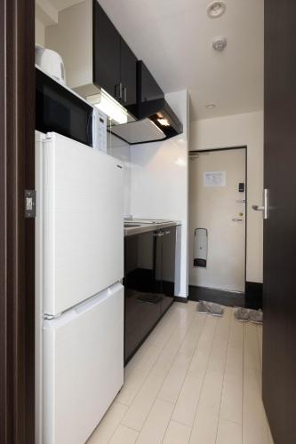 a kitchen with white appliances and a white tile floor at 錦系町天空樹景觀飯店 Skytree View Kinshicho in Tokyo