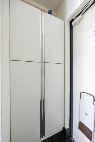 a glass refrigerator in a room with a mirror at 錦系町天空樹景觀飯店 Skytree View Kinshicho in Tokyo