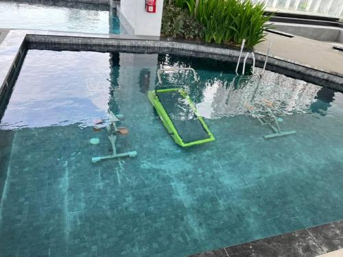 a pool with a green raft in the water at Penang Georgetown 3BRCPGF The Martian #TvBox in Jelutong
