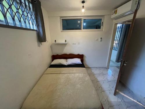 een kamer met een bed in de hoek van een kamer bij Confortable 2 bedrooms - Center of Osu noble house in Accra