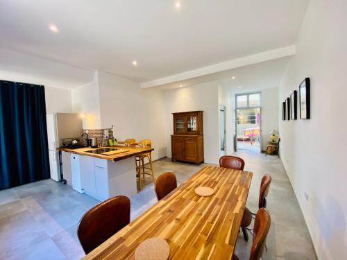 a kitchen and dining room with a wooden table at Oasis Urbaine - Spacieux et calme avec patio in Lille