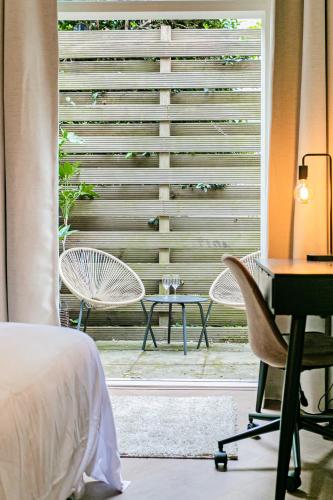 a bedroom with a large window with a desk and chair at Stylish apartment next to the Amstel River - Unit A in Amsterdam