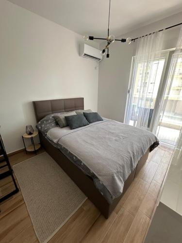1 dormitorio con 1 cama grande en una habitación blanca en WIN centar apartman, en Trebinje