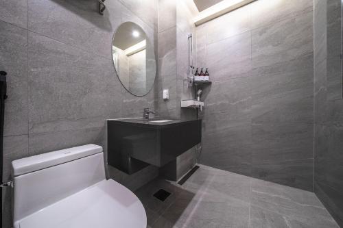 a bathroom with a toilet and a sink and a mirror at Bluebird Hotel in Incheon