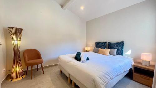 une chambre avec un grand lit et une chaise dans l'établissement Superbe Villa EmmaZen climatisée, à Sainte-Maxime