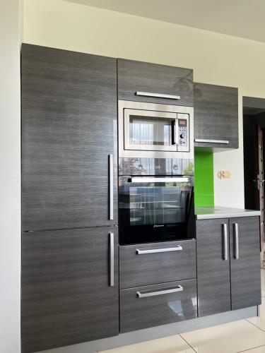 uma cozinha com armários de madeira e um micro-ondas em Dom w Zawadzie Lanckorońskiej 101 em Zakliczyn