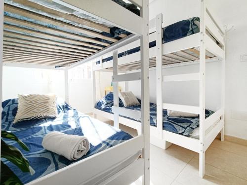 a bedroom with two bunk beds in a room at Sunny Blue Home - near Pools, Beach and Golf in Los Alcázares