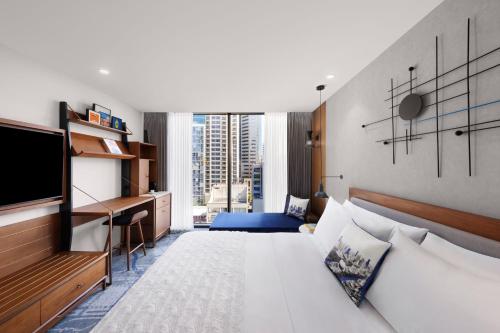a hotel room with a bed and a desk at Le Méridien Melbourne in Melbourne