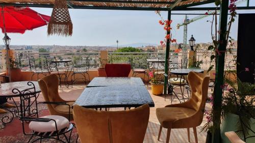 un patio con mesas y sillas y vistas. en Golf Stinia hôtel & Spa en Meknès